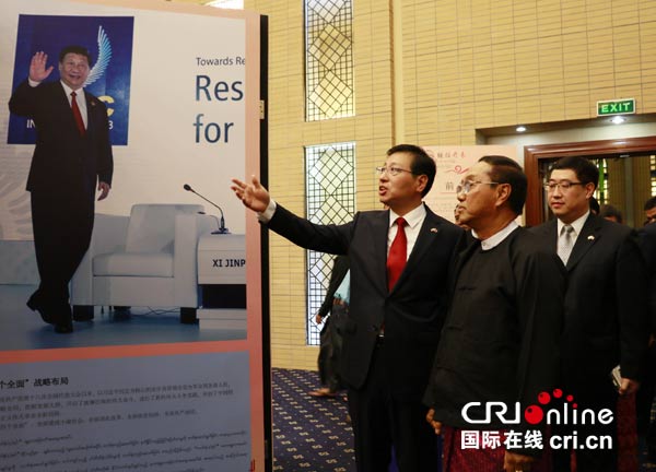 中国驻缅大使洪亮(左一)为缅甸副总统敏瑞讲解"砥砺前行,继往开来"