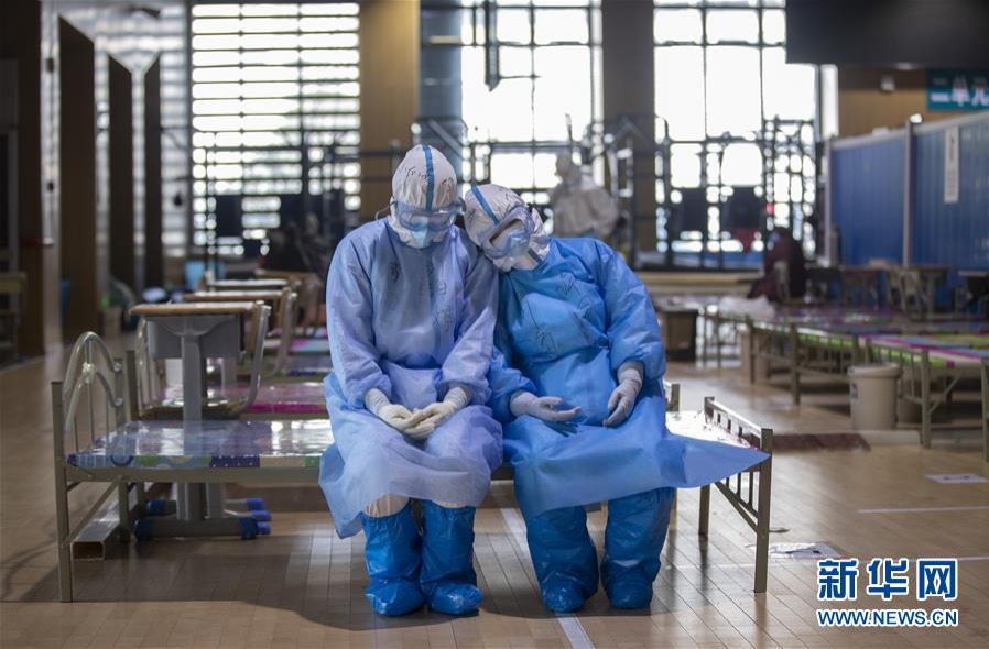 这是3月10日，在武昌方舱医院，两位青海医疗队队员在等待新冠肺炎治愈患者出舱时小憩。 新华社记者 费茂华 摄