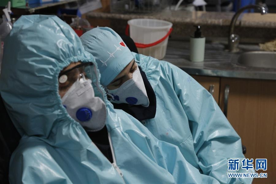 这是3月28日，在伊朗一家医院，身穿防护服的医务人员在工作间隙休息。 新华社发（伊朗国家通讯社供图）