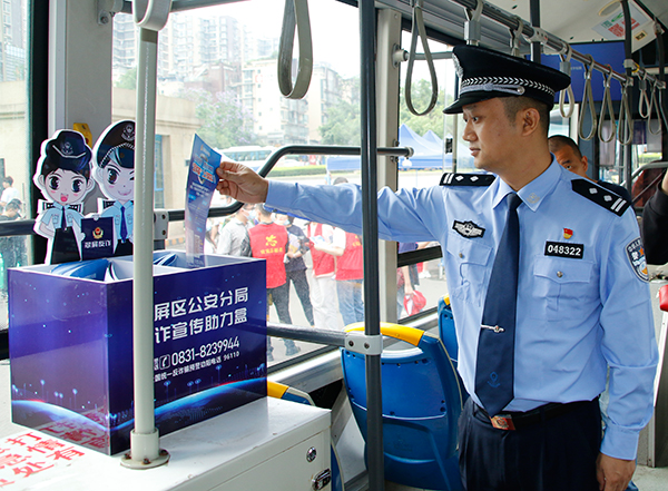 宜宾翠屏反诈主题公交车启动仪式举行_fororder_民警在检查宣传资料-摄影-高学兵