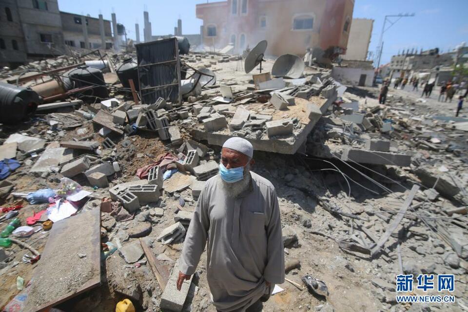 5月20日,巴勒斯坦人在加沙地带的拉法查看以色列空袭后的建筑废墟.