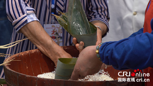 端午民俗文化旅游节丰富浙江湖州新农村文化建设_fororder_村民在进行包粽子比赛 摄影：秦靓.JPG