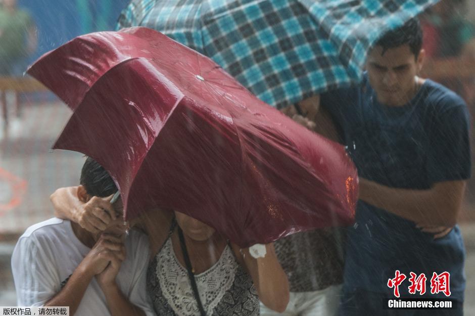 巴西里约迎暴风雨天气 民众撑伞出行风中凌乱