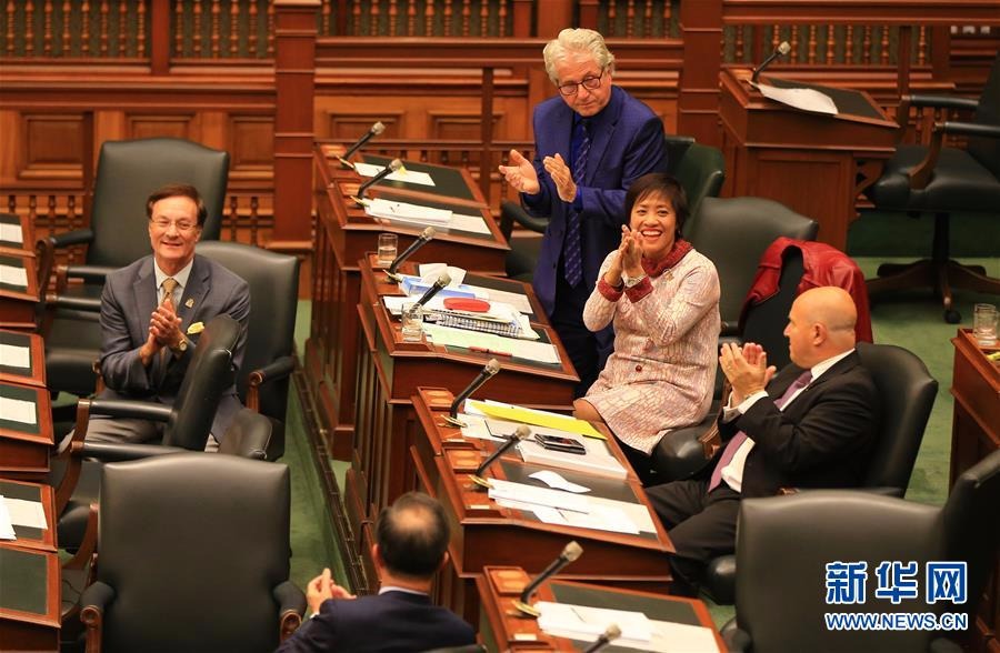 10月26日，在加拿大多伦多，安大略省议会议员黄素梅（右二）与同事鼓掌庆祝动议获通过。（新华社 邹峥摄）