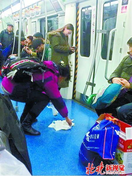 北京地铁乘客晕车呕吐 “正能量姐”俯身擦净呕吐物