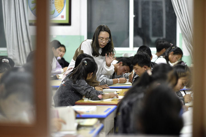 复旦大学第23届研究生支教团支教老师徐菁在晚自习上为学生解答问题(9