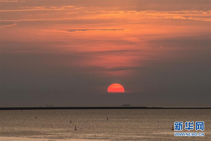 落日余晖映海口