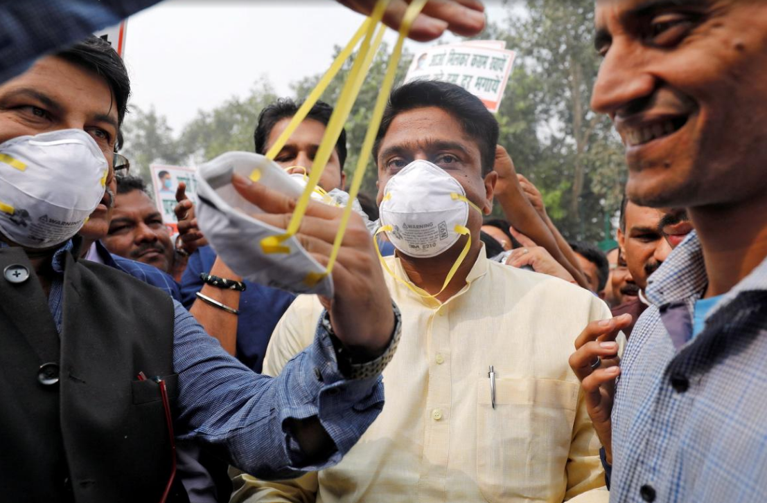 印度人民党主席马诺吉·蒂瓦里帮助一名男子戴上面具_fororder_QQ截图20171110170016