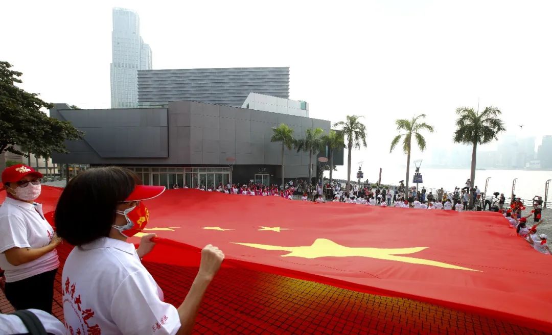 香港市民在中环手持五星红旗跑步,表达对祖国美好祝愿.