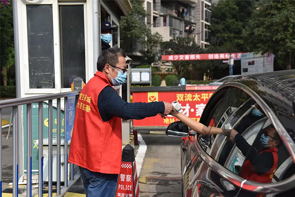 防疫有序｜成都双流一线抗“疫”工作者冲锋在前 用心守护居民“绿码”_fororder_党员志愿者给过路的市民测体温-供图-成都市双流区委宣传部