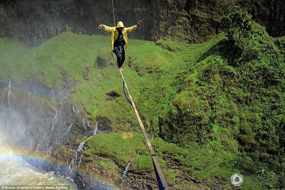 组图：绝美瀑布之巅 小伙高空走扁带穿越彩虹