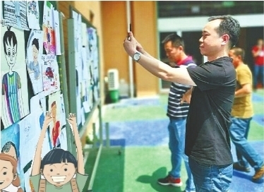 小學生變身小畫家 爸爸們在200張卡通畫像中找自己