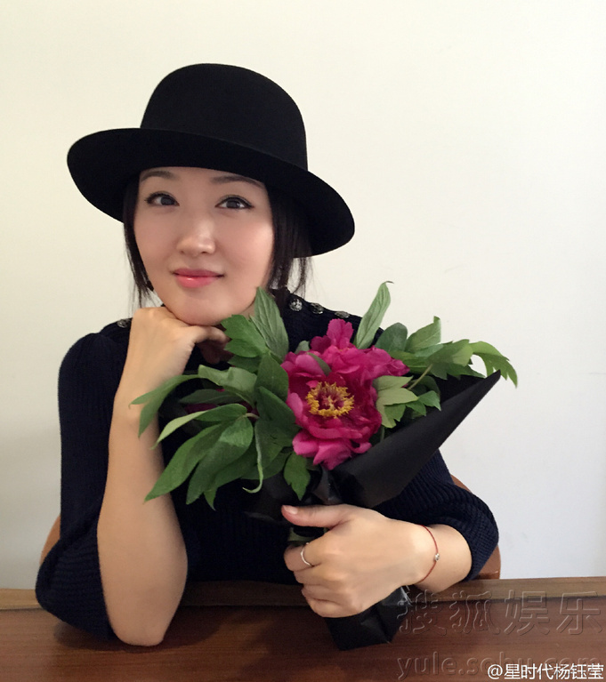 悠闲时光！杨钰莹抱花赏画 皮肤白皙笑容甜