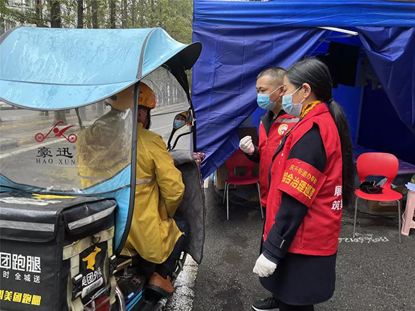 防疫有序｜成都双流一线抗“疫”工作者冲锋在前 用心守护居民“绿码”_fororder_社区工作人员帮居民领取快递-供图-成都双流区委宣传部