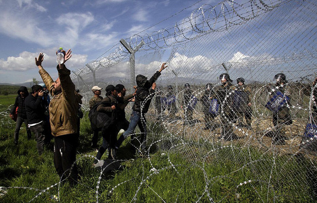 在希腊与马其顿边境冲突中,这名年轻移民将催泪瓦斯罐投掷回去.