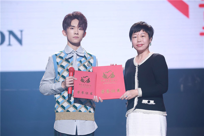 图片默认标题_fororder_易烊千玺与中国扶贫基金会秘书长助理秦伟女士合影