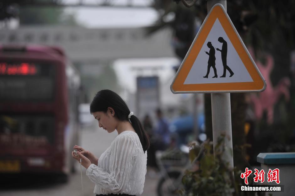 重庆一红绿灯处摆放“不做低头族”警示牌