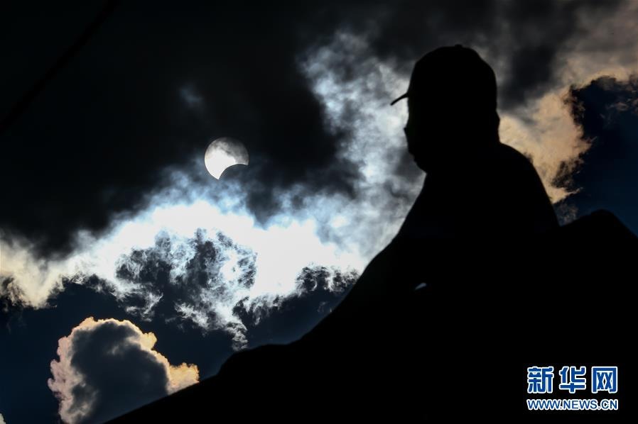 6月21日，一名男子在菲律宾马尼拉观看日食。新华社发（乌马利摄）