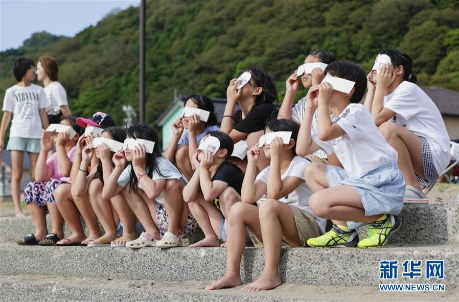 6月21日，人们在日本福井县福井市观看日食。新华社/共同社