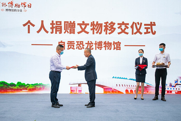 蜥脚类恐龙尾椎化石,象牙雕观音等珍贵物品现场进行了交接仪式.