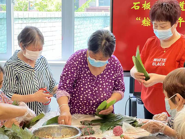 成都东部新区石板凳街道桐子坳社区举办端午节主题活动_fororder_居民们在包粽子-供图-成都市东部新区党群工作部宣传处