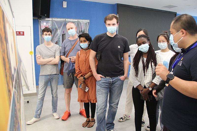 （只审不发）“丝路青年”点赞成都大运会里的“科技+智慧”元素_fororder_新都香城体育中心工作人员正在为丝路青年介绍场馆情况-摄影--李婷