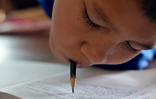 印尼11岁男孩天生无四肢 用下巴做功课打游戏(组图)