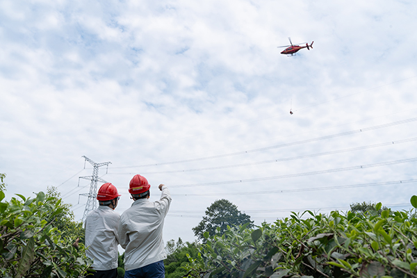 四川：直升飞机带电作业 紧急消除电力隐患_fororder_工作人员监视直升飞机带电作业安全（廖望摄）