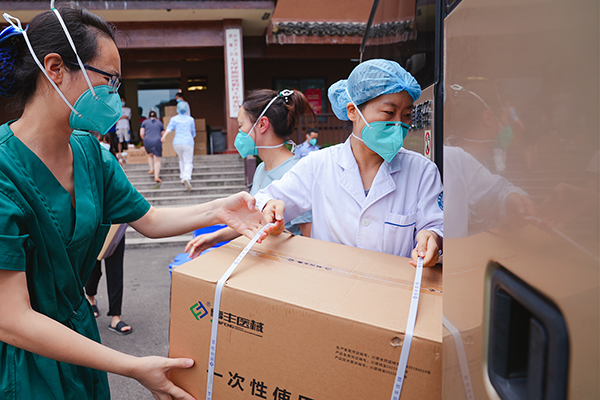 直击眉山疫情防控现场｜你若不退 我便守护到底——记眉山医警夫妻的坚守_fororder_王丽谕（右）在一线转运医疗物资-受访者供图