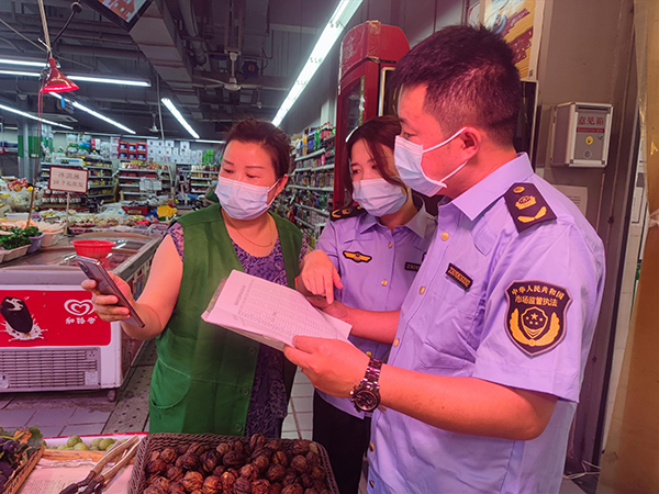 成都武侯：买得放心 吃得安心 文明农贸市场守护舌尖安全_fororder_武侯区益民菜市场中的店铺正在接受监管部门检查2-供图-成都市武侯区融媒体中心