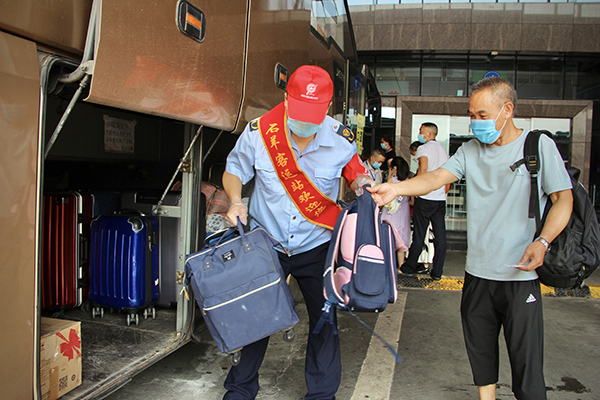 直面高温“烤”验 坚守交通一线——致敬高温下的文明交通守护者_fororder_客运场站的工作人员帮助乘客提放行李-供图-成都市交通运输局