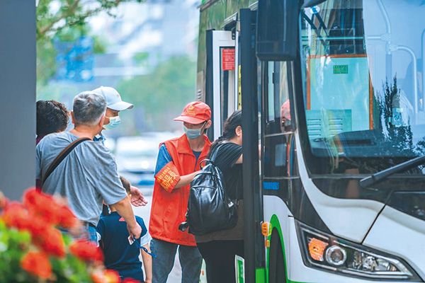 直面高温“烤”验 坚守交通一线——致敬高温下的文明交通守护者_fororder_公交站点文明劝导员引导乘客排队上车--供图-成都市交通运输局