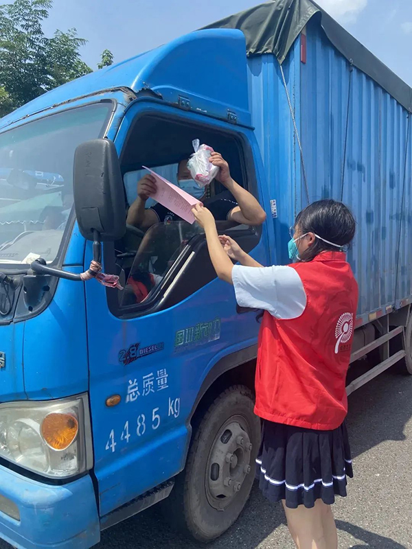 直面高温“烤”验 坚守交通一线——致敬高温下的文明交通守护者_fororder_高速路上志愿服务队员为货车司机讲解防疫政策-供图-成都市交通运输局