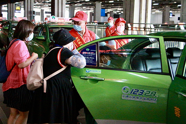 直面高温“烤”验 坚守交通一线——致敬高温下的文明交通守护者_fororder_成都东站志愿者引导乘客有序乘车-供图-成都市交通运输局