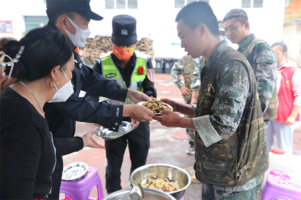 瀘定地震特別報道 | 磨西震區安置點群眾：有你們的守護 我們很安心_fororder_志願者為民警盛上飯菜-供圖-甘孜州公安局