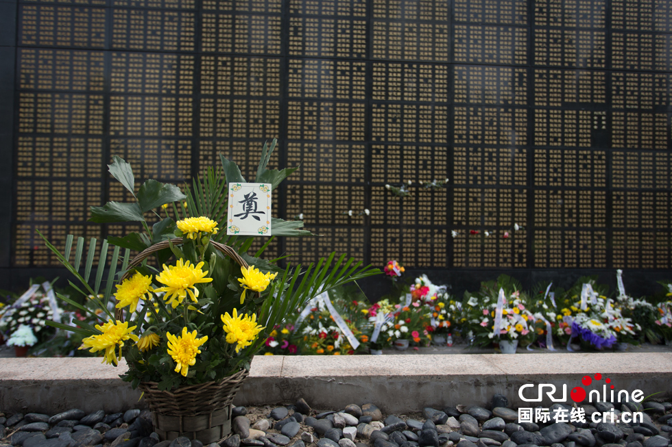 纪念墙下敬献的鲜花和纪念品