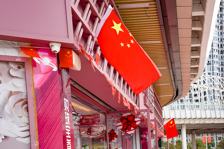 自贡市用满城的“中国红”表达着对祖国生日的满满祝福_fororder_华商一商店门口用五星红旗装扮店铺