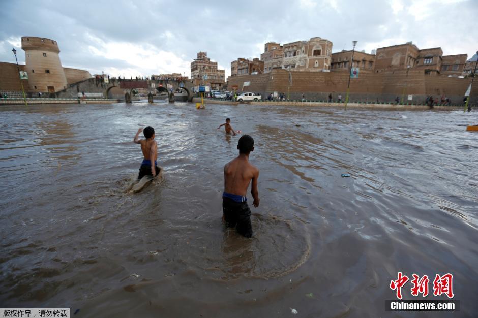 也门首都暴雨引发洪涝 儿童跳入水中游泳