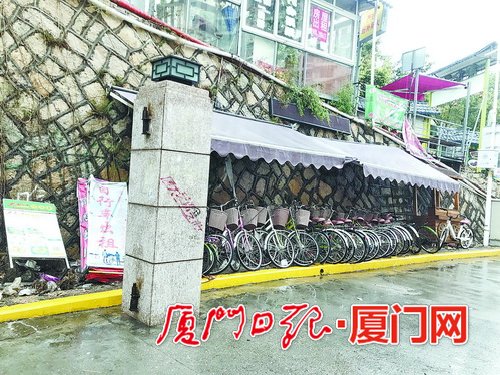 【法治 主推】【滚动新闻】【地市 厦门】(摘要:记者来到厦大芙蓉隧道出口黄女士所说的自行车棚附近。发现设置在一处斜坡石壁下的紫色车棚已微微泛白,十几辆自行车歪歪斜斜地停在棚内,一旁写有“自行车出租”的广告牌倒在地上。走近一看,车把手、座椅上都覆盖了一层灰,车身锈迹斑斑,车轮里还有不少零食包装袋和纸杯。)厦大芙蓉隧道出口自行车棚无人管 人行道垃圾成堆 【法治 主推】【滚动新闻】【地市 厦门】(摘要:记者来到厦大芙蓉隧道出口黄女士所说的自行车棚附近。发现设置在一处斜坡石壁下的紫色车棚已微微泛白,十几辆自行车歪歪斜斜地停在棚内,一旁写有“自行车出租”的广告牌倒在地上。走近一看,车把手、座椅上都覆盖了一层灰,车身锈迹斑斑,车轮里还有不少零食包装袋和纸杯。)厦大芙蓉隧道出口自行车棚无人管 人行道垃圾成堆