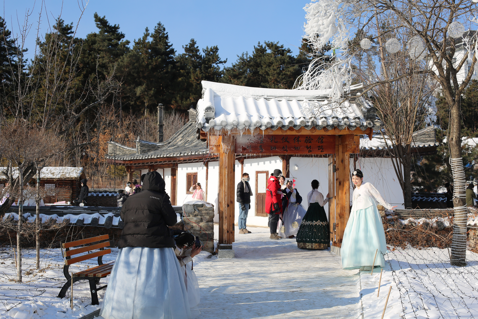 第十届延吉国际冰雪旅游节开幕式将于12月31日举行_fororder_游客在中国朝鲜族民俗园内参观拍照 供图 延吉市委宣传部
