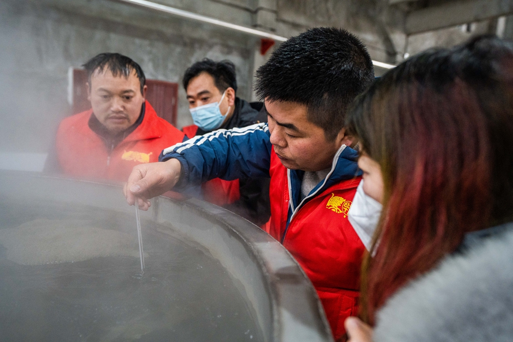 贵州毕节：初冬下沙酿酒忙_fororder_2022年12月3日，工人在贵州毕节酒厂的制酒车间里查看冷却塔的温度。