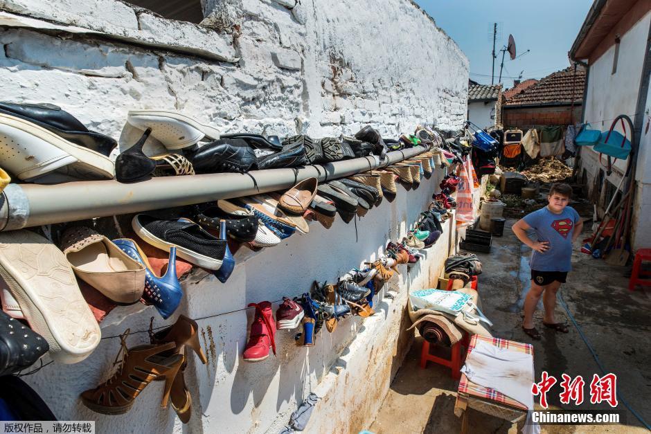 马其顿居民进行洪涝清理工作 房前晾满鞋子“蔚为壮观”