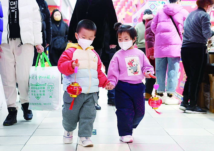 歡喜年味_fororder_商場內，小朋友手拿著紅燈籠興奮地和家長一起逛街購物。