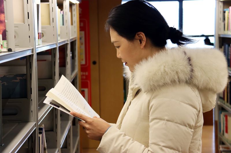 南阳：书香春节“充电”忙_fororder_市民在南阳图书馆书架前找书.JPG