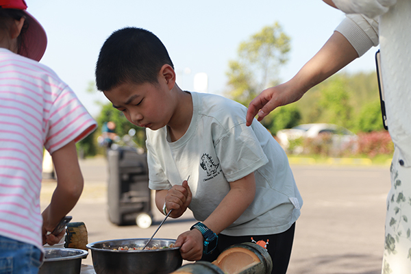 （张）宜宾市兴文县僰王山研学旅行实践营地今日开营_fororder_孩子们在学做竹筒饭-供图-蜀南文旅集团