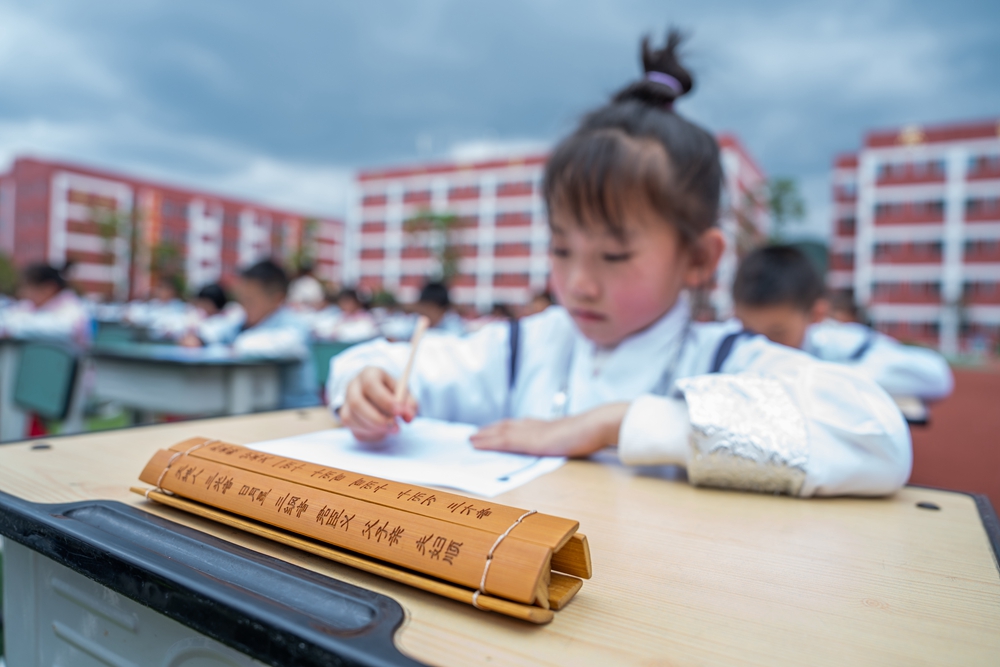 贵州毕节：诵“国学” 展“国韵”_fororder_2023年5月12日，学生们在贵州省毕节梁才学校操场上参加书写汉字古文活动。  (2)