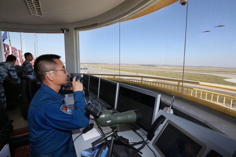 空军驻疆航空兵某旅旅长沈元中担任当日飞行塔台指挥员(8月25日摄).