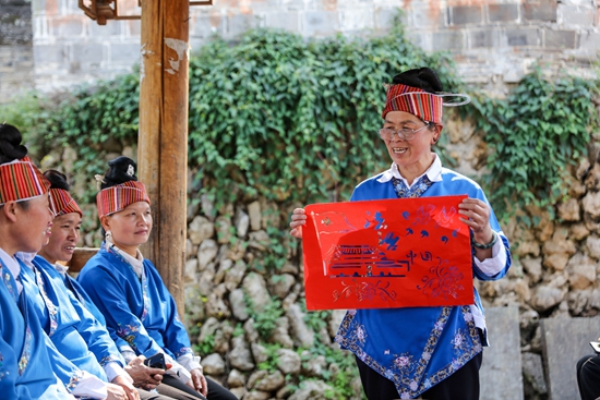 （供稿）贵州施秉：“非遗”苗族剪纸助力法治宣传_fororder_2023年4月18日，在贵州省黔东南苗族侗族自治州施秉县双井镇龙塘村，“非遗”苗族剪纸省级传承人张老英给苗族群众展示、讲解法治宣传剪纸作品。（磨桂宾 摄） (3).JPG