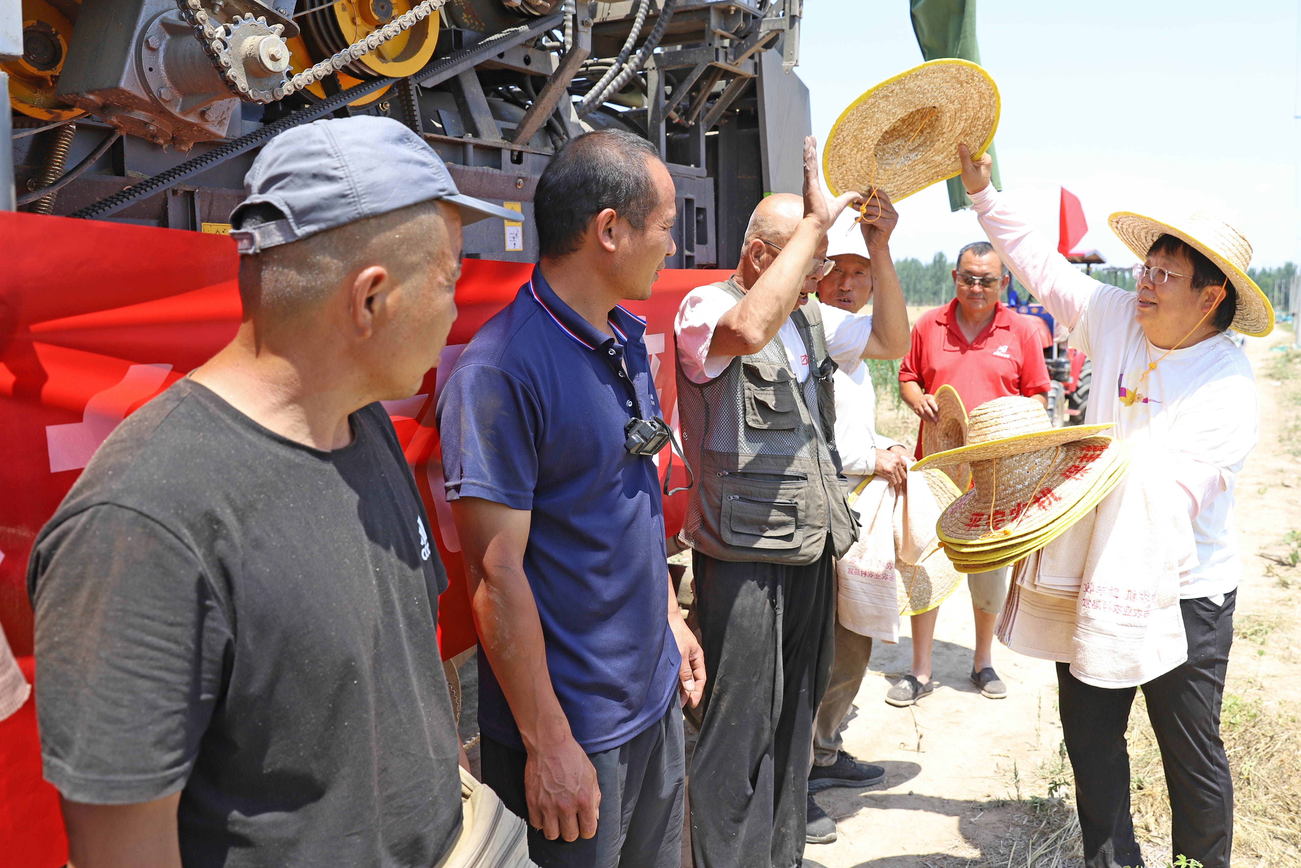 （原创）河北涿州：做好农机跨区作业服务工作 护航“三夏”麦收_fororder_6月14日河北涿州豆庄镇南香营村，服务站工作人员深入田间地头为跨区作业农机手发放防暑物品。熊华明摄