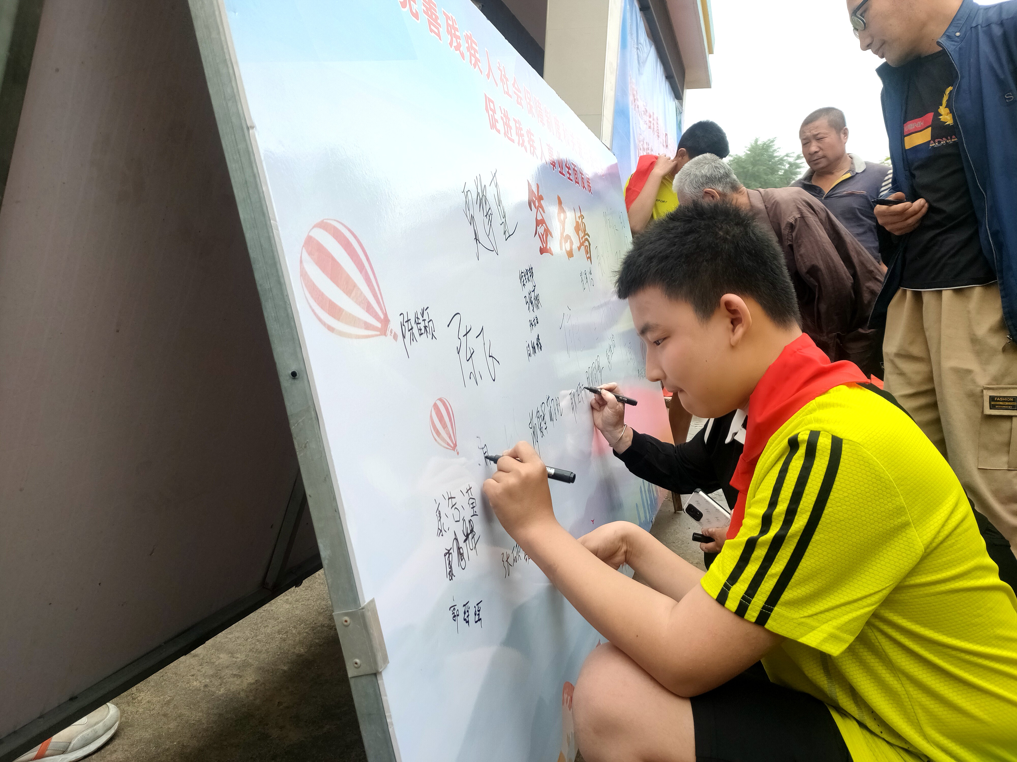 图片默认标题_fororder_参加活动的孩子们和爱心使者在签名墙上留下亲笔签名1